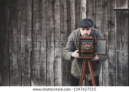 Photographer prepares for shooting on large format camera. Concept - photography of the 1930s-1950s, matte effect
