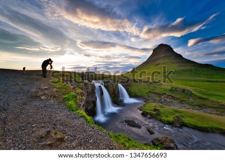 Photographers are photographing at kirkjufell waterfall, mountains and waterfalls in the evening. Twilight skies are beautiful.