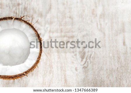 half coconut on a light white wooden background, closeup. Top view