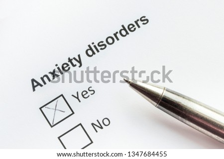 Anxiety disorders word write on paper.  The pen is on a blank sheet. Selective focus