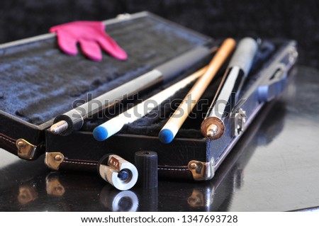 Open trunk cue case and the cues for the game of pool Royalty-Free Stock Photo #1347693728