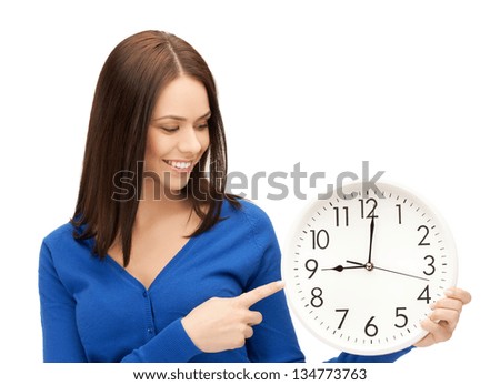 attractive businesswoman pointing her finger at wall clock Royalty-Free Stock Photo #134773763