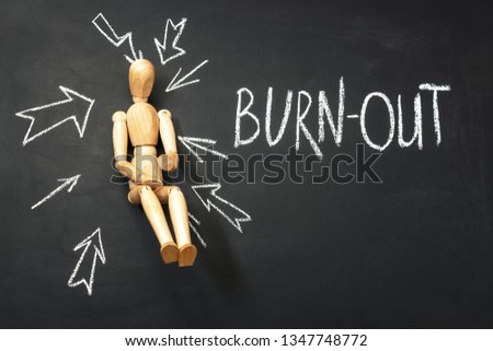 wooden man and inscription burn out on a chalkboard