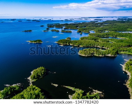 Aerial view of blue lakes and green forests on a sunny summer day in rural Finland. Drone photography from above Royalty-Free Stock Photo #1347782420