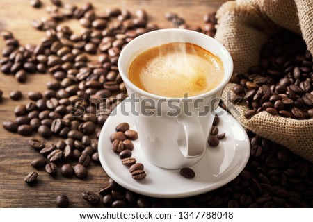 cup of coffee and coffee beans on wooden table Royalty-Free Stock Photo #1347788048
