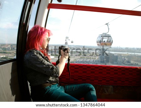 Woman in cable car taking pictures