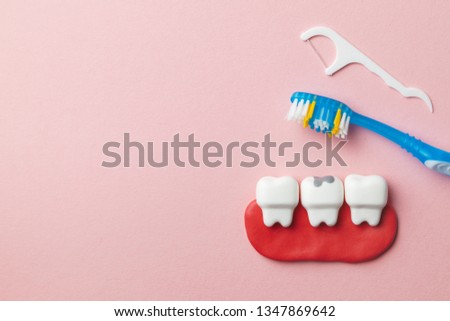 Healthy white teeth and tooth with caries on pink background and Toothbrush and dental floss. Copy space for text