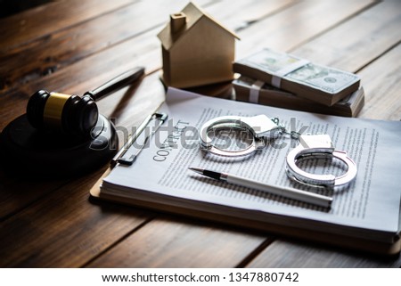 The handcuff is placed on a contract of sale. The concept is not fair to the contract. Royalty-Free Stock Photo #1347880742
