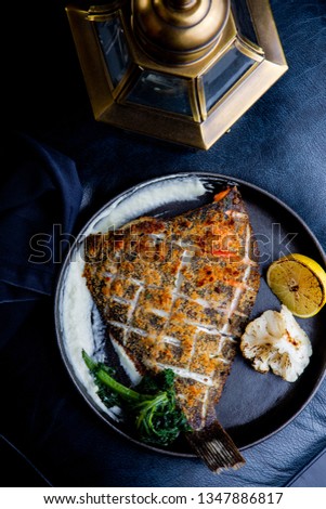 Flounder fillet roasted in a skillet with herbs and lemon
