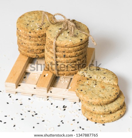 Sesame cookies pile with rustic twine isolated on a white background, square picture, closeup