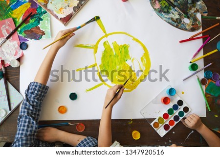 Above view background of two children drawing sun while painting picture together, copy space