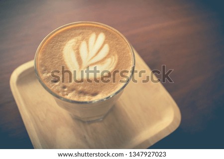 Picture of  latte or cappuccino coffee with latte art on a wooden table