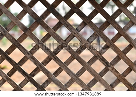 Wooden grid in the Park on the background of greenery and pond 