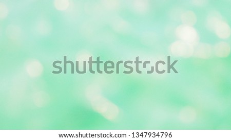 Abstract blurred focus of beautiful round bokeh lights in light green and turquoise tone for glossy background and festive decoration. Seasons greetings and celebrations concept. Ocean and sea theme