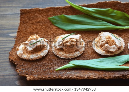 Toasts with chicken liver pate on rustic background,wild garlic leaves.