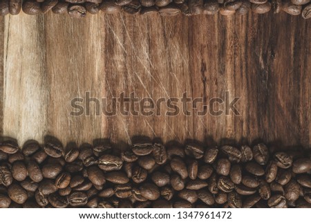 Coffee beans arranged on a wooden surface for use as a background image.