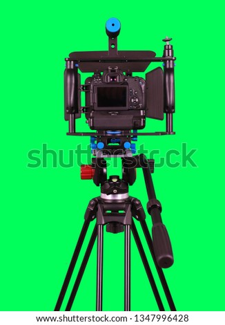 Dslr camera with empty screen for video shooting with green screen on the tripod isolated on green background. The chromakey. Green screen.