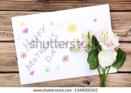 Greeting card for Mothers Day with flowers on brown wooden table