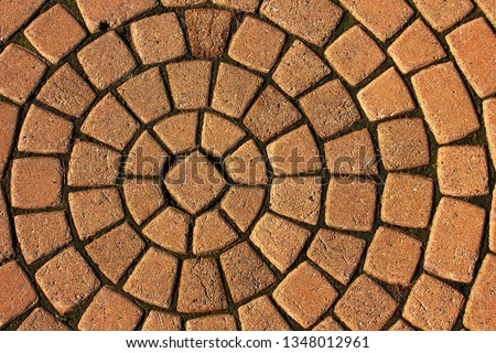 brown stone blocks in the form of rings. texture of stone pavement. Granite cobblestone pavement background. Abstract background cobblestone pavement closeup Royalty-Free Stock Photo #1348012961
