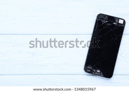 Broken smartphone on wooden table
