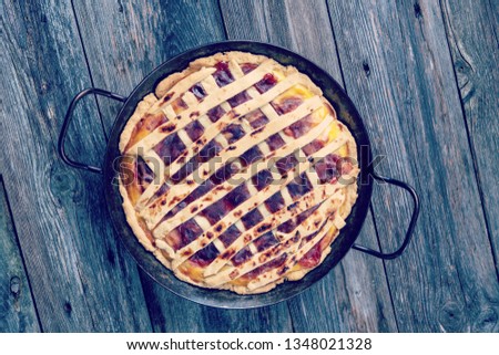 sweet pie in iron pan on wooden ground