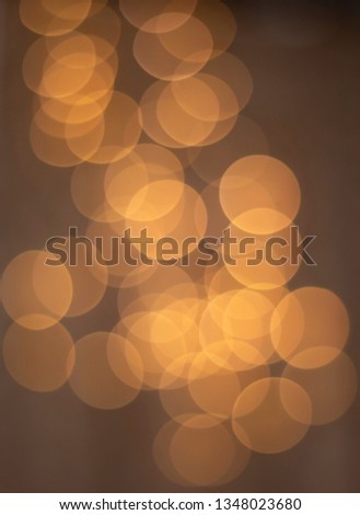 Abstract brown / golden bokeh background - wallpaper. Circles of bright lights in the dark