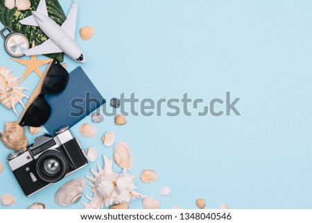 Preparation for Traveling concept, watch, airplane, money, passport, pencils, book, Photo frame, eyeglass on blue background with copy space.