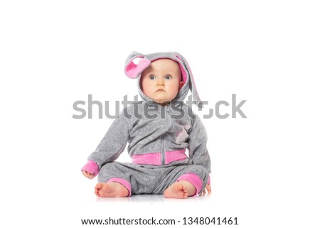 Cute little baby in bunny costume sitting on white background. children's games. baby emotions.