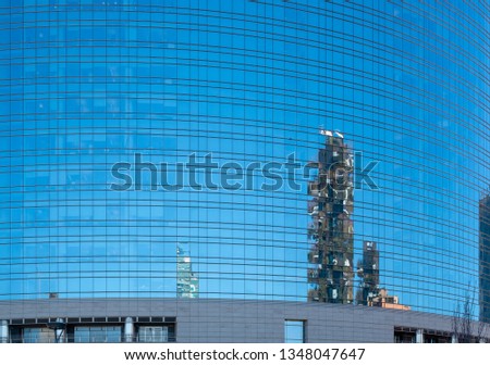Modern buildings are reflected on the glass wall. Milan, Lombardy, Italy.