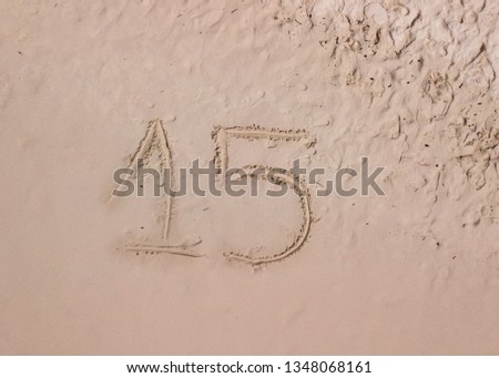 Number 15 written on the sand of a tropical beach. Celebrating 15 years birthday debut party. 15 years anniversary. 