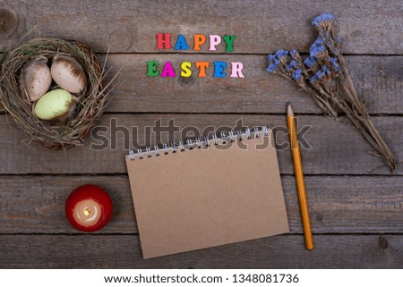 Easter background. The inscription of the multicolored wooden letters "Happy Easter". Bird's nest with eggs and a blank notebook for records. For instagram, Flat Lay, Copy space.