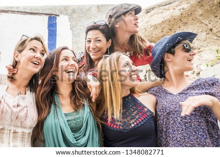 Group of cheerful happy young caucasian women hug and enjoy the vacation together smiling and posing for a picture - people having fun in friendship - all women concept for travel and lifestyle