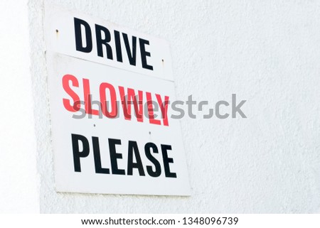 Drive slowly road safety sign