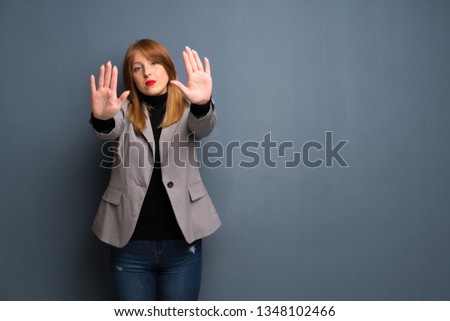 Redhead business woman making stop gesture for disappointed with an opinion