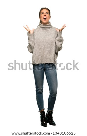 A full-length shot of a Blonde woman with turtleneck frustrated by a bad situation over isolated white background
