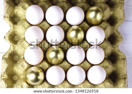 Eggs. White and golden eggs in carton package. Symmetry background concept.