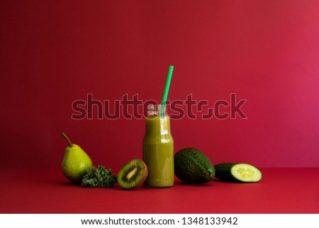 Healthy detox smoothie with green vegetables and fruit lie on the red table. Copy space, red backgrounds wall. Mental balance, diet, lifestyle.