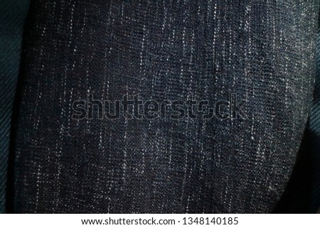 Close up texture of navy blue fabric blanket or throw. Black,grey and white vertical flecks in thread of woven material. Useful as texture map or background