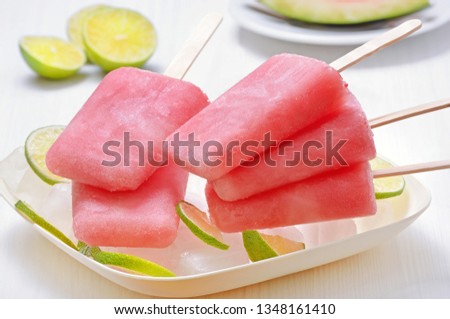 Popsicles from frozen watermelon on plate on a white table