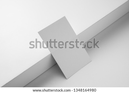 Design concept - perspective view of horizontal business card isolated on white background with heavy shadow for mockup, it's real photo, not 3D render