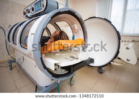 young guy in a hyperbaric chamber, oxygen treatment, medical chamber Royalty-Free Stock Photo #1348172510
