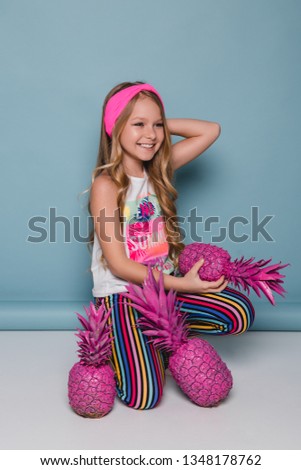 Kid fashion model, blue background, girl with pink pineapple