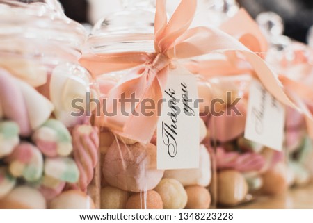 Marshmallow sweets in a transparent jar with a Thank You message around the neck of jar as a Birthday party return sweet treat