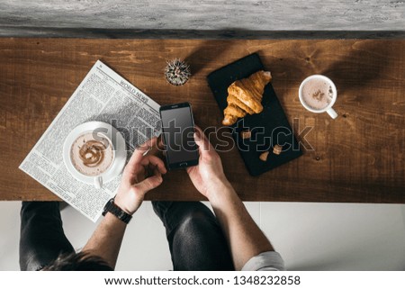 Young man in cafe read newspaper with strong coffee