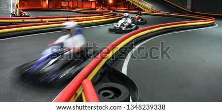 Riding in kart indoors at high speed. Active leisure, entertainment on the karting track