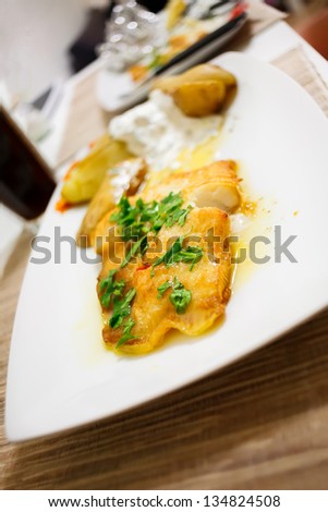 Grilled halibut with lemon sauce and parsley. Shallow depth of field for beauty.