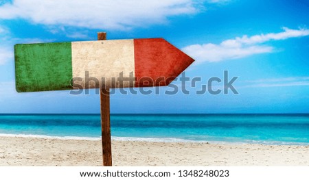 Italy flag on wooden table sign on beach background. It is summer sign of Italy.