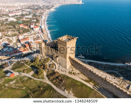 Genoese fortress in Sudak, Crimea. Aerial panorama view of ruins of ancient historic castle or fortress on crest of mountain near sea. Beautiful summer tourist landscape Royalty-Free Stock Photo #1348248509