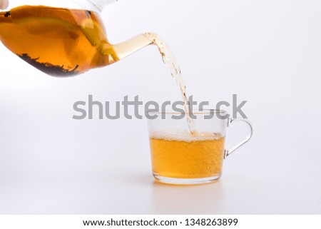 Green tea pouring into glass cup Isolated on white background