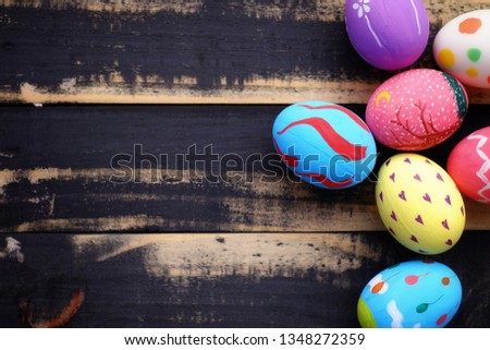 Colorful hand painted easter eggs with pink distress wooden background, pastel colors eggs, each with a unique pattern.